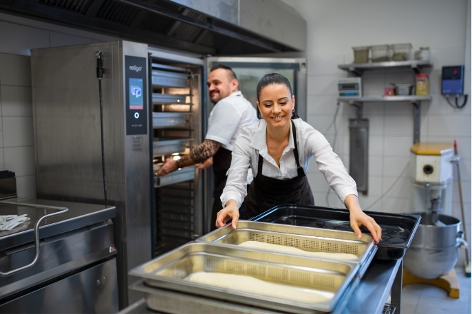 man and woman making bread in restaurant