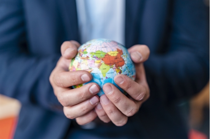 small globe cradled in hands